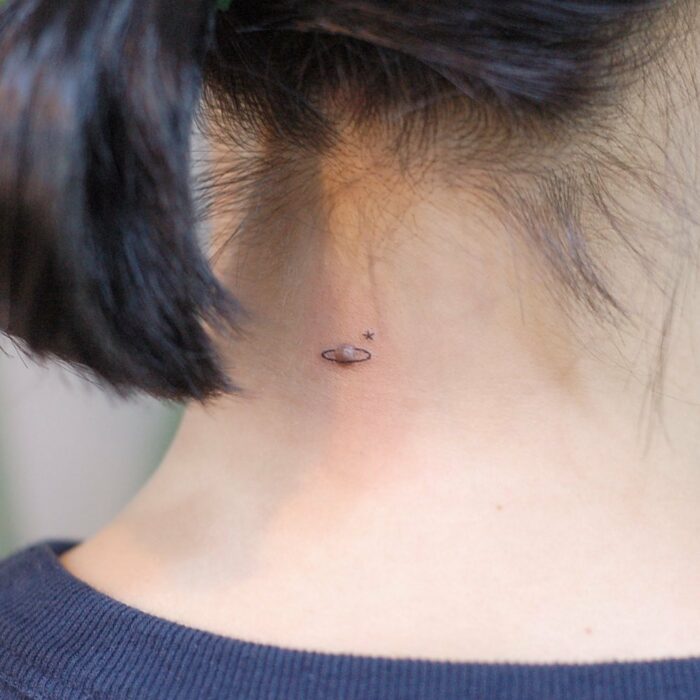 nape of a woman with a planet tattoo 