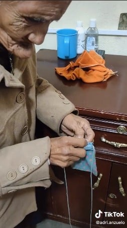 Abuelita sacando dinero de su monedero 