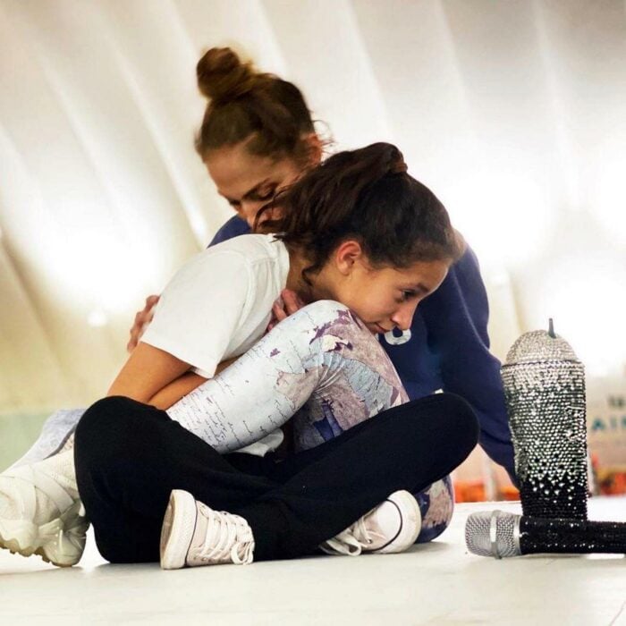 Jennifer Lopez en el suelo abrazando a su hija Emme