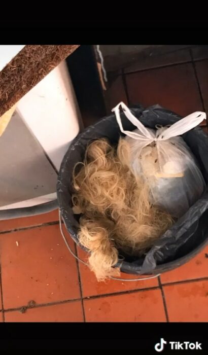 bote de basura con un montón de cabello dentro 