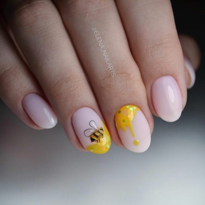 diseño de uñas con una abeja siguiendo la miel 