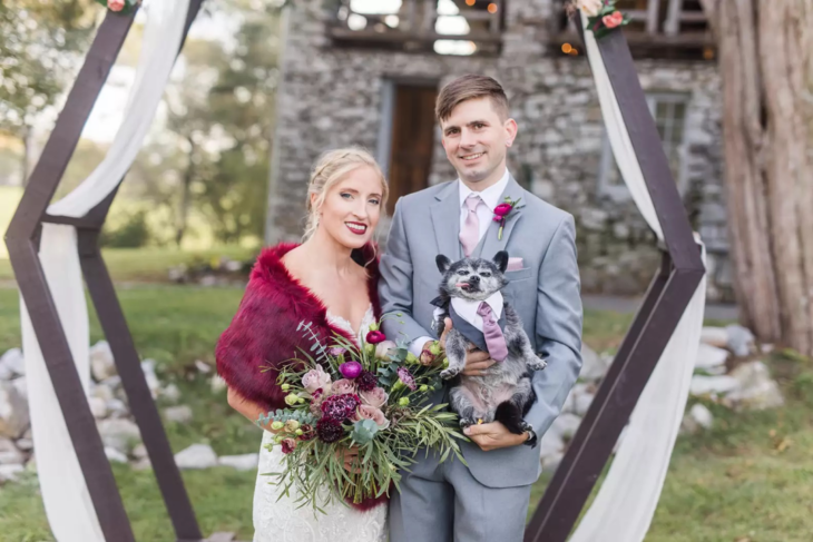 pareja cargando a su perrito el día de su boda 