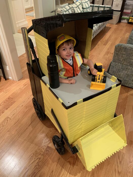 niño en una silla de ruedas en forma de excavadora 