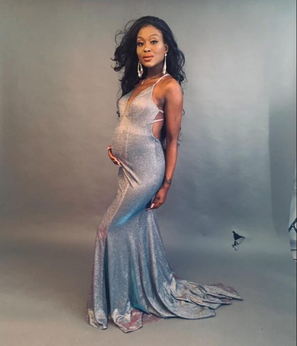 mujer embarazada posando en una sesión de fotos con un vestido de fiesta en color gris 