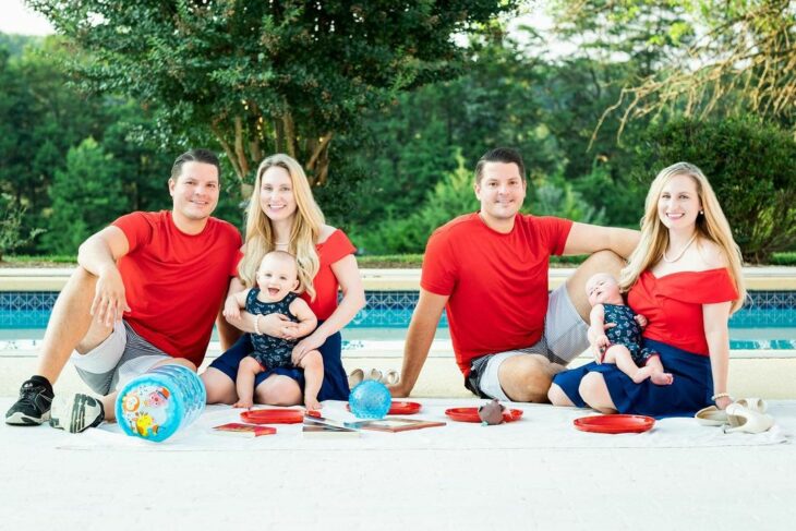 two married couples dressed in the same color in front of a pool 