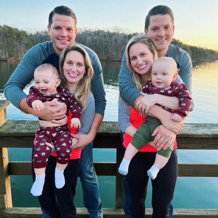 photo of a twin married couple with their babies on a pier 