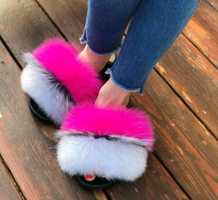 pies de una chica luciendo unas pantuflas furry con peluche de colores