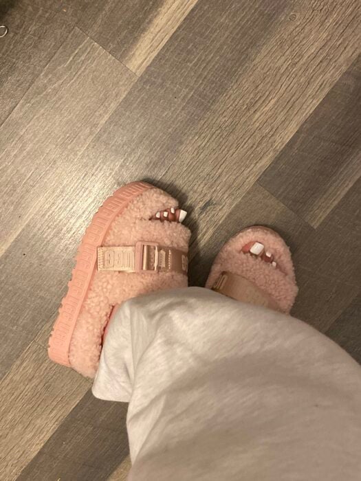 pies de una chica usando pantuflas Furry en color rosa pastel