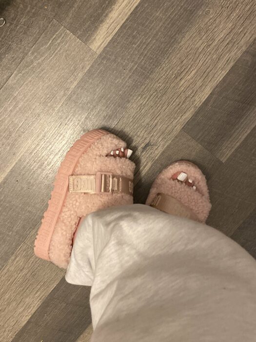 feet of a girl wearing pastel pink furry slippers