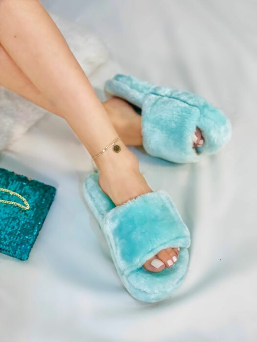 feet of a girl wearing fuzzy slippers in sky blue color