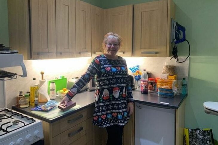 foto de una mujer posando frente a una cocina de una casa 