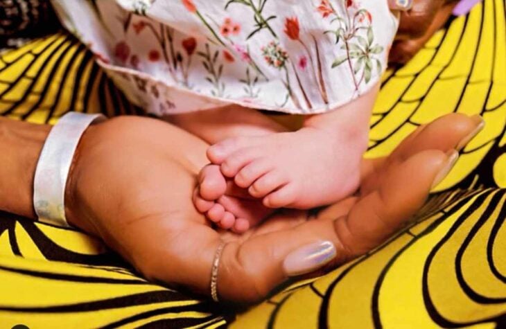 Naomi Campbell sujetando pies de su hija