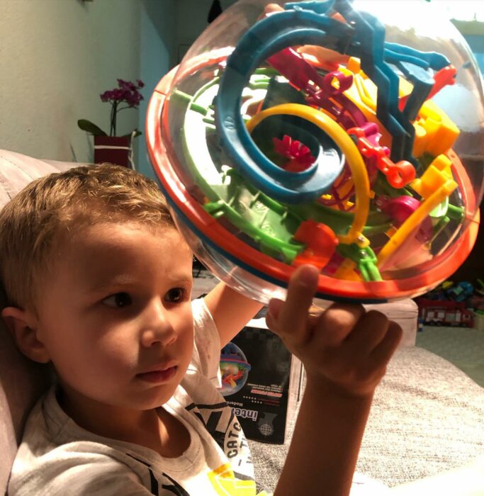 niño jugando con un juguete de figuras 