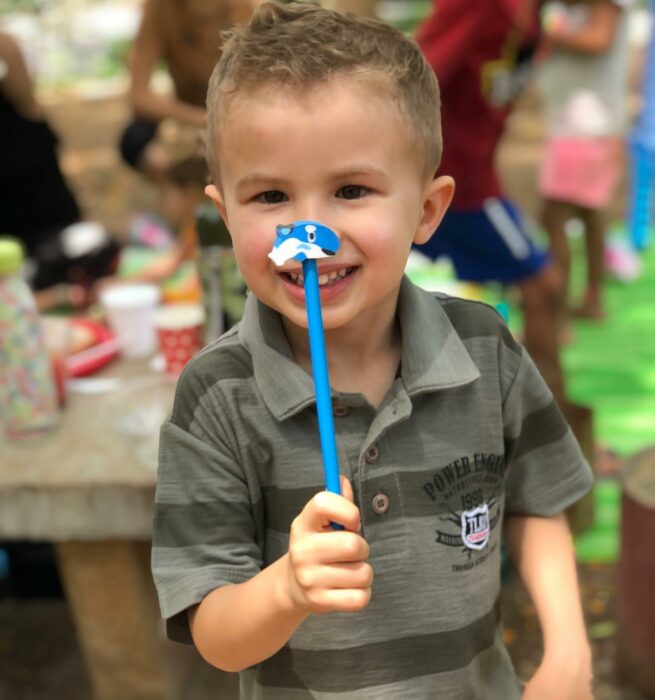 niño sosteniendo un lápiz frente a su cara 