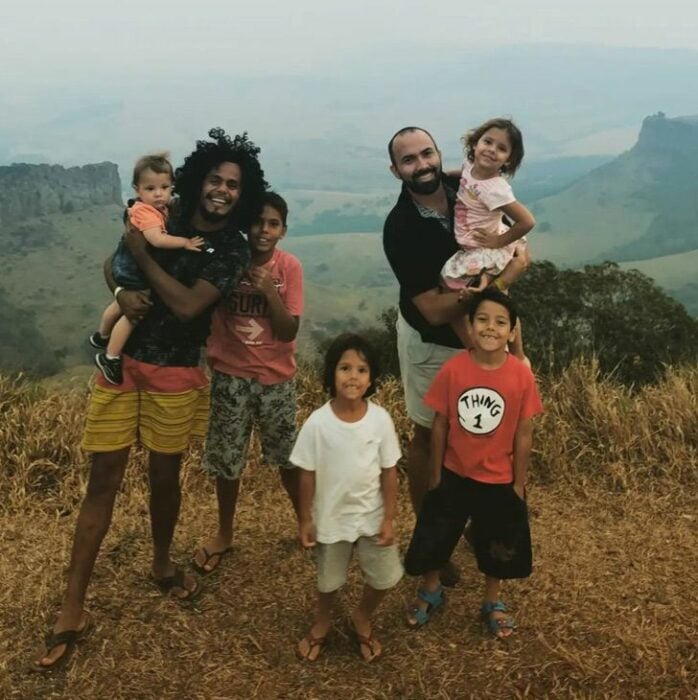 pareja gay posando con sus 5 hijos en un lugar a la interperié