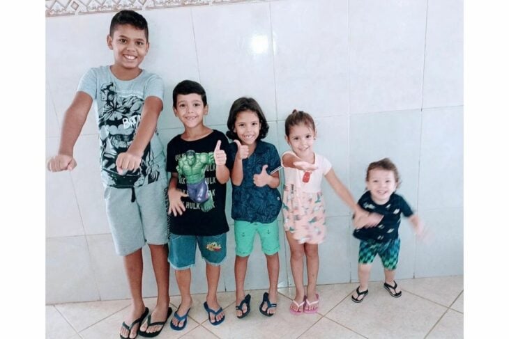 imagen de 5 niños formados frente a una pared 