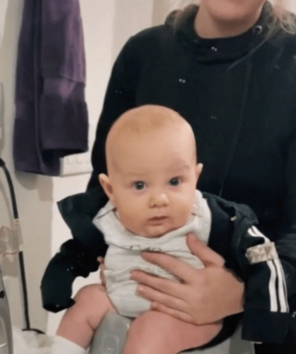 a few weeks old baby sitting on a potty 