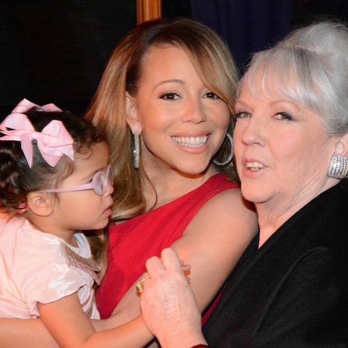 Mariah Carey cargando a una niña junto a Patricia Carey