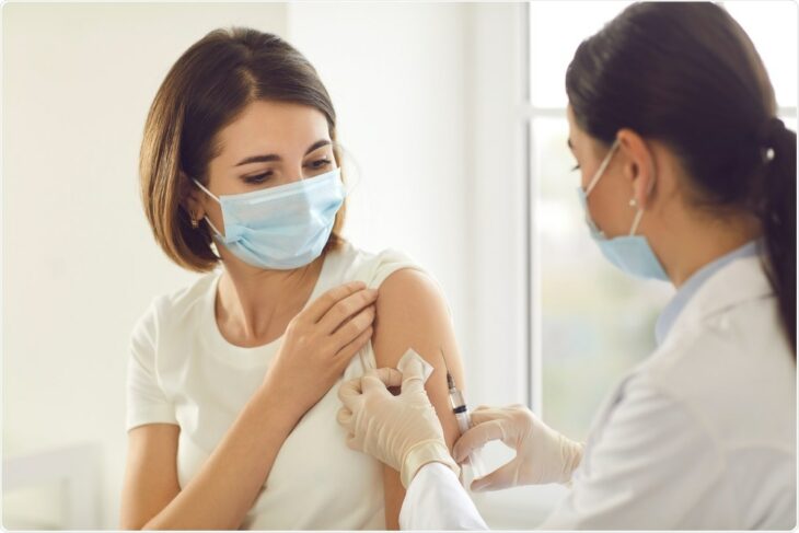 Woman being vaccinated by another