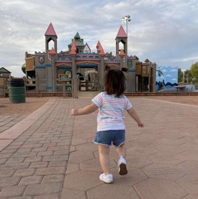 foto de una pequeña niña corriendo hacia un castillo 
