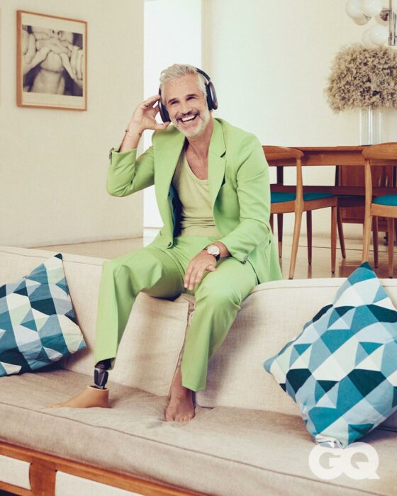 Juan Pablo Medina posando en la sala de su casa con traje verde 