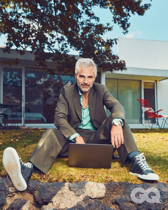 Juan Pablo Medina sentado sobre el pasto frente a una laptop 