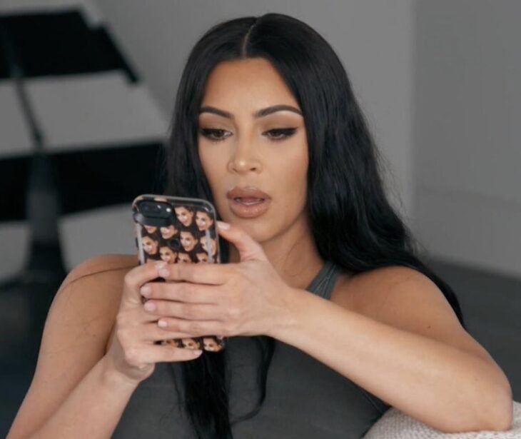 Kim Kardashian viendo su teléfono celulcar