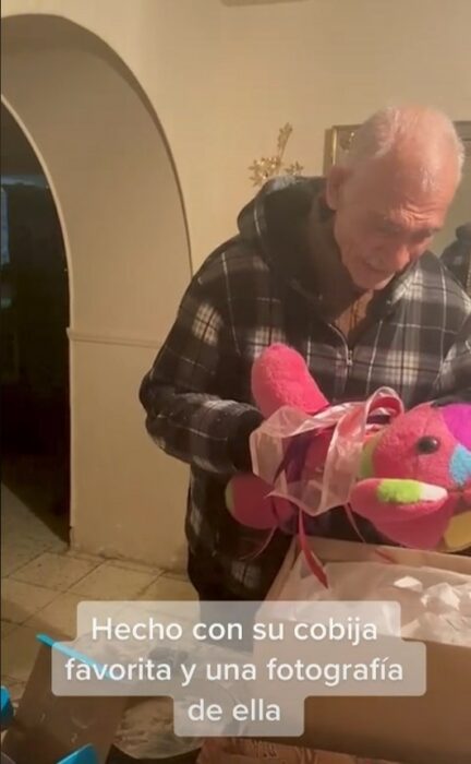 abuelito viendo de cerca a un oso de peluche en color rosa 