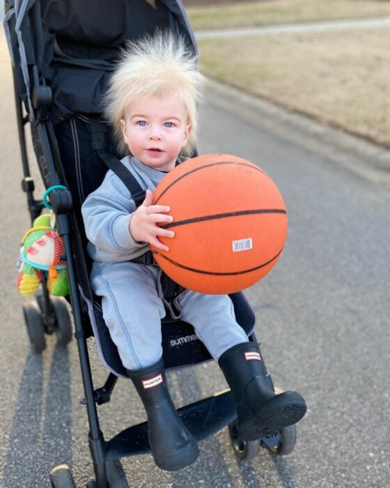 pequeño niño en su carriola con un balón de basquetball 