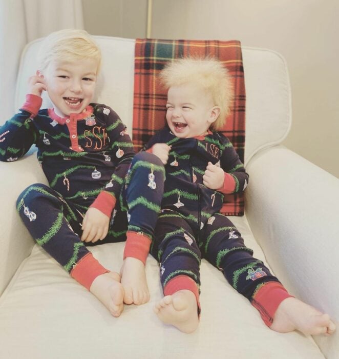 dos niños con pijama igual sentados en un sillón 