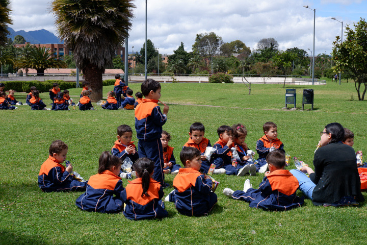 Image of some children in a circle taking classes outdoors 