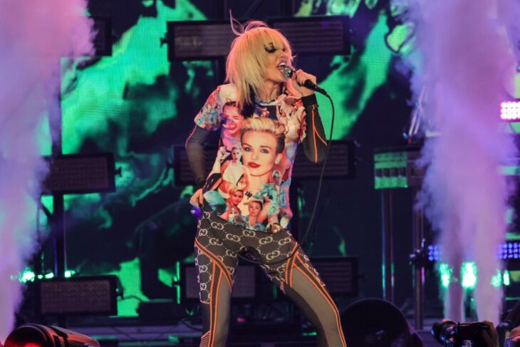 Miley Cyrus cantando en un escenario durante un concierto