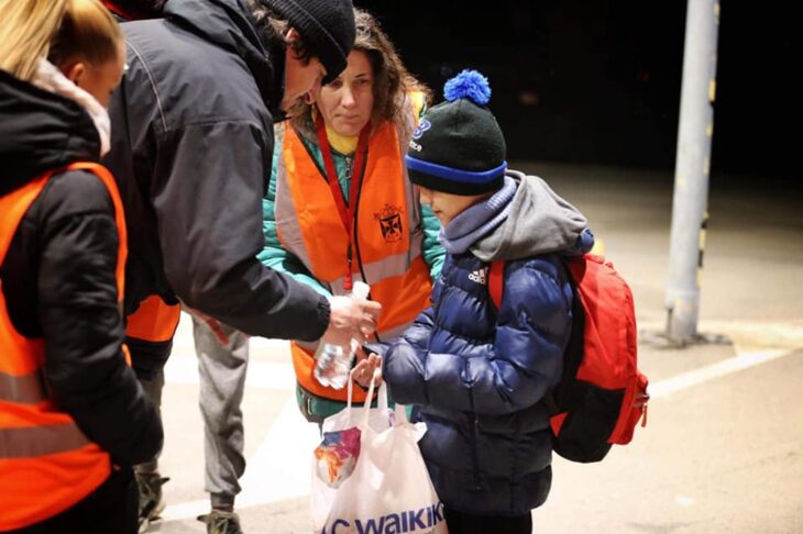 Niño siendo ayudado por voluntarios ante la invasión Rusa en Ucrania 