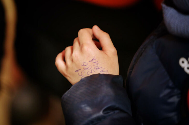 child's hand with a phone number written on it 