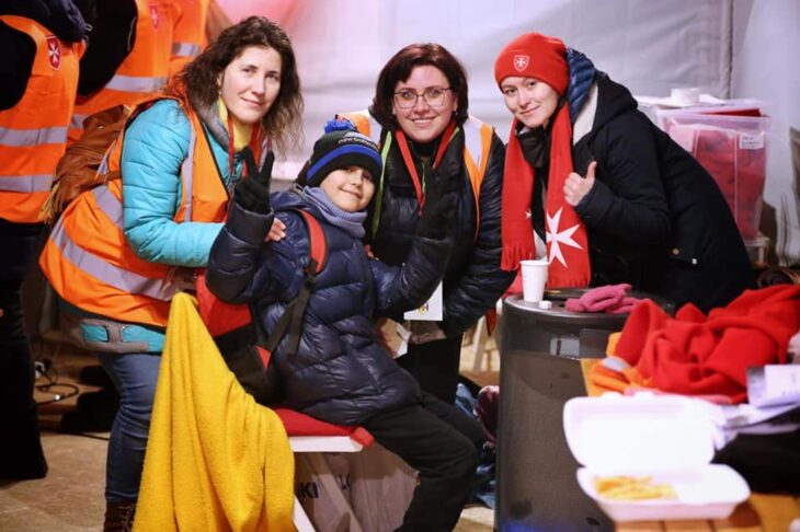 Ukrainian child next to female volunteers on the border of Slovakia 