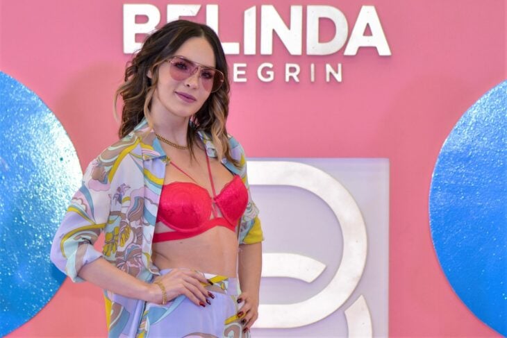 Belinda posando con un top rosa y gafas en color rosa 