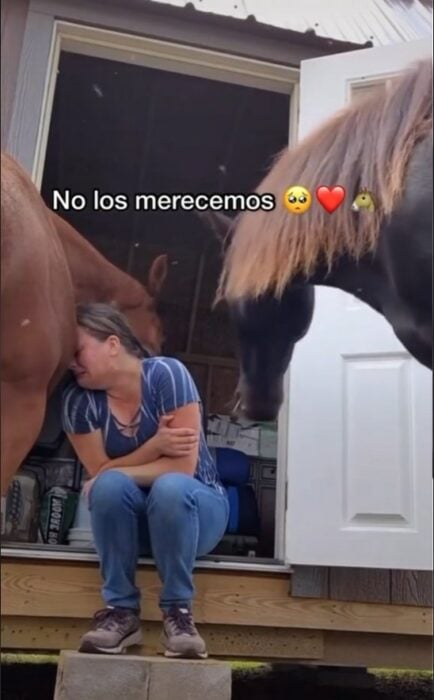 mujer llorando recargando su cabeza sobre el caballo 