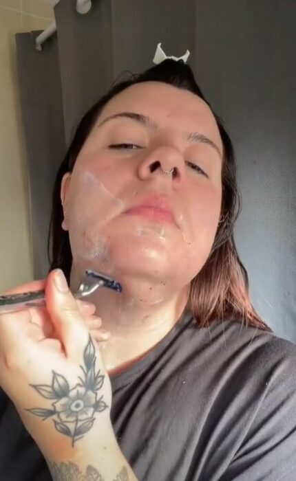 Mujer rasurando su cara 