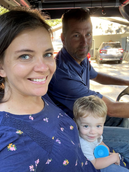 selfie de una mujer cargando a un bebé en el auto a lado de un hombre 