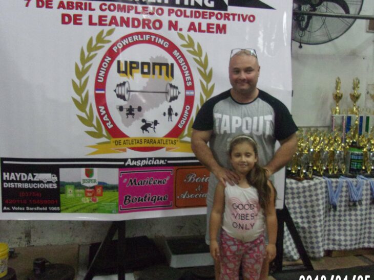 Man accompanied by his daughter at an awards ceremony for bodybuilding 