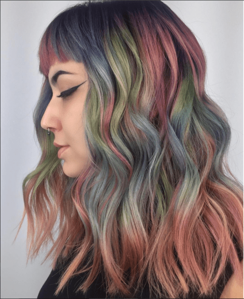 modelo mostrando un cabello pintado con más de 3 tonalidades con un cabello con ondas 