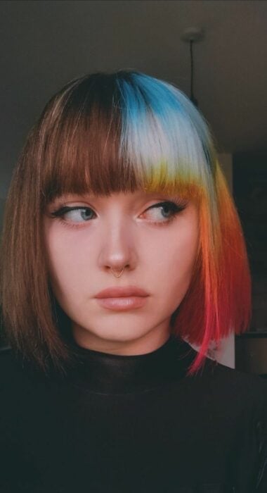 cara de una chica que trae la mitad de su cabello pintado de varios colores