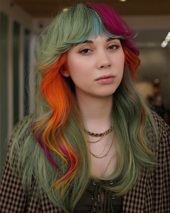 chica de cabello rubio verdoso con algunos mechones en color naranja 