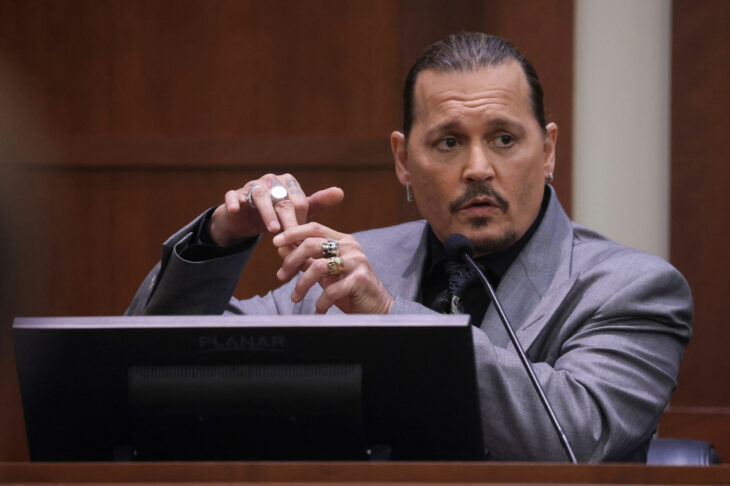 Actor Johnny Depp in court holding the middle finger of his right hand 