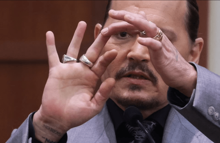 Actor Johnny Depp agarrando su dedo medio cortado 