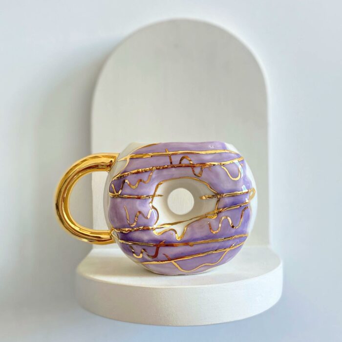 Dona lila con dorado; Artista crea tazas en forma de donas y son tan lindas que se antoja morderlas