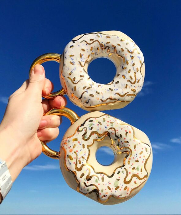 Donas blancas con dorado; Artista crea tazas en forma de donas y son tan lindas que se antoja morderlas