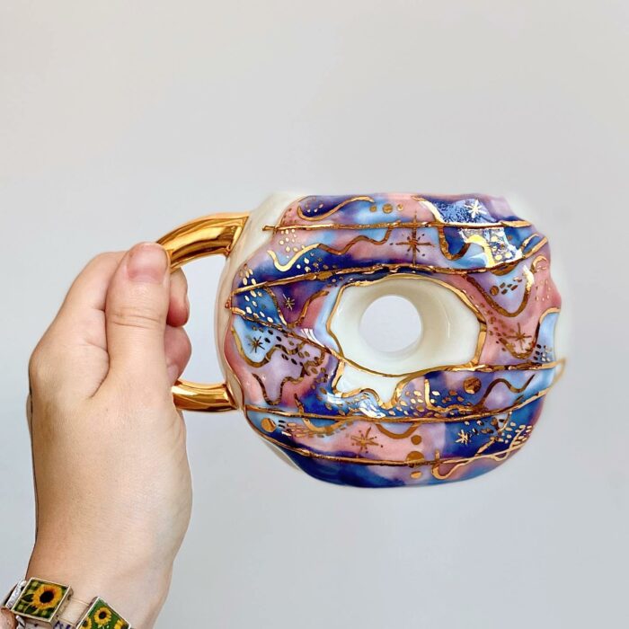 Dona con morado y azul cielo; Artista crea tazas en forma de donas y son tan lindas que se antoja morderlas