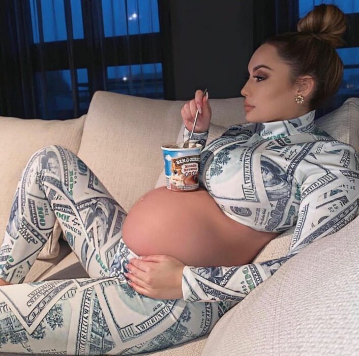 pregnant woman lying on a couch with a snow bucket on her belly