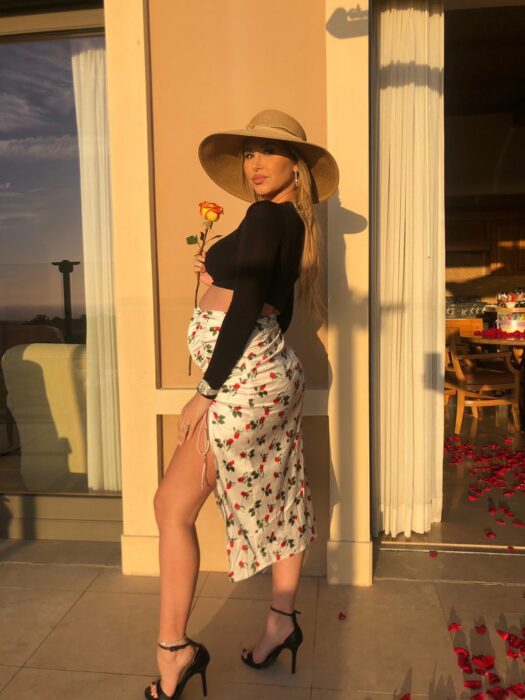 Photograph of a pregnant woman posing outside a restaurant 